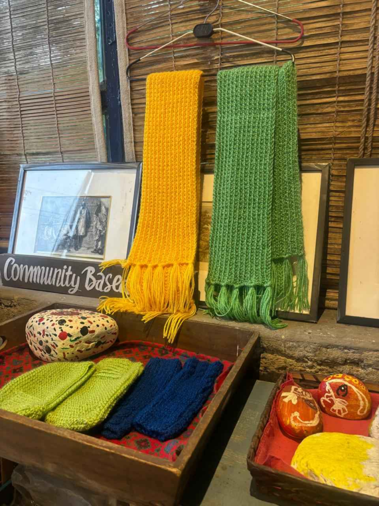 The café now features a dedicated counter displaying handcrafted items from local women, such as knitted mufflers and shawls.
